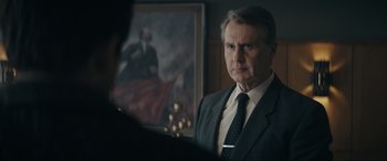 Movie still from “Tetris” (2023), directed by Jon S. Baird – A person wearing a suit and tie; Close Up shot, Over the shoulder angle