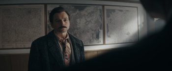 Movie still from “Tetris” (2023), directed by Jon S. Baird – A man in a suit and tie standing in front of a mirror; Close Up shot, Over the shoulder angle