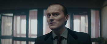 Movie still from “Tetris” (2023), directed by Jon S. Baird – A person wearing a suit and tie; Close Up shot, Low angle