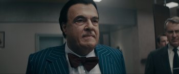 Movie still from “Tetris” (2023), directed by Jon S. Baird – An older man in a suit and bow tie; Close Up shot, Low angle