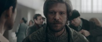 Movie still from “Tetris” (2023), directed by Jon S. Baird – A person with a beard and mustache; Close Up shot, Over the shoulder angle