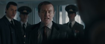 Movie still from “Tetris” (2023), directed by Jon S. Baird – A person wearing a suit and tie; Close Up shot, Over the shoulder angle