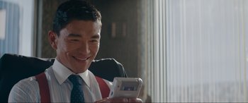 Movie still from “Tetris” (2023), directed by Jon S. Baird – A man in a white shirt and a tie is holding a phone; Close Up shot, Over the shoulder angle