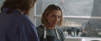 Movie still from “That's Amor” (2022), directed by Shaun Paul Piccinino – A woman in an apron looking at a man in an apron; Close Up shot, Over the shoulder angle