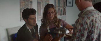 Movie still from “That's Amor” (2022), directed by Shaun Paul Piccinino – A man and a woman holding a metal pan; Medium shot, Low angle