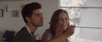 Movie still from “That's Amor” (2022), directed by Shaun Paul Piccinino – A man and a woman sitting next to each other; Close Up shot, Over the shoulder angle