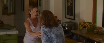 Movie still from “That's Amor” (2022), directed by Shaun Paul Piccinino – Two women talking in a living room; Medium shot, Over the shoulder angle