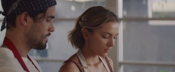 Movie still from “That's Amor” (2022), directed by Shaun Paul Piccinino – A woman with short brown hair is looking down at a man; Close Up shot, Over the shoulder angle