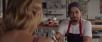 Movie still from “That's Amor” (2022), directed by Shaun Paul Piccinino – A man sitting at a table in front of a woman; Close Up shot, Over the shoulder angle