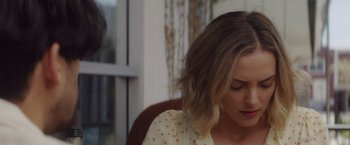 Movie still from “That's Amor” (2022), directed by Shaun Paul Piccinino – A person sitting in front of a window; Close Up shot, Over the shoulder angle