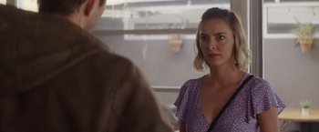 Movie still from “That's Amor” (2022), directed by Shaun Paul Piccinino – A woman in a purple dress looking at a man in a brown shirt; Close Up shot, Over the shoulder angle