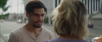 Movie still from “That's Amor” (2022), directed by Shaun Paul Piccinino – A man with long black hair talking to a woman; Close Up shot, Over the shoulder angle