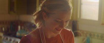 Movie still from “That's Amor” (2022), directed by Shaun Paul Piccinino – A person wearing an orange shirt; Close Up shot, Over the shoulder angle