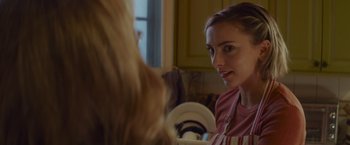 Movie still from “That's Amor” (2022), directed by Shaun Paul Piccinino – A woman in an apron looking at another woman in an apron in a kitchen; Close Up shot, Over the shoulder angle