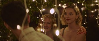 Movie still from “That's Amor” (2022), directed by Shaun Paul Piccinino – Two women standing next to each other in front of lights; Close Up shot, Over the shoulder angle