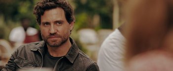 Movie still from “The 355” (2022), directed by Simon Kinberg – A person wearing a leather jacket; Close Up shot, Over the shoulder angle