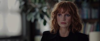 Movie still from “The 355” (2022), directed by Simon Kinberg – A person with red hair; Close Up shot, Over the shoulder angle