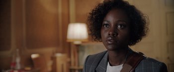 Movie still from “The 355” (2022), directed by Simon Kinberg – A person wearing a suit; Close Up shot, Over the shoulder angle