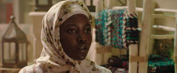 Movie still from “The 355” (2022), directed by Simon Kinberg – A person wearing a headscarf; Close Up shot, Over the shoulder angle