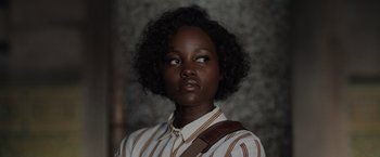 Movie still from “The 355” (2022), directed by Simon Kinberg – A young woman with a bag in her mouth; Close Up shot, Low angle