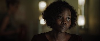 Movie still from “The 355” (2022), directed by Simon Kinberg – A person with short curly hair; Close Up shot, Over the shoulder angle