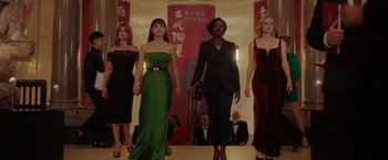 Movie still from “The 355” (2022), directed by Simon Kinberg – A group of women walking down a runway in formal wear; Wide shot, Low angle