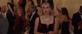 Movie still from “The 355” (2022), directed by Simon Kinberg – A woman in a red dress is standing in front of a crowd; Close Up shot, Over the shoulder angle