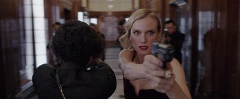 Movie still from “The 355” (2022), directed by Simon Kinberg – A woman holding a gun in front of a man; Close Up shot, Over the shoulder angle