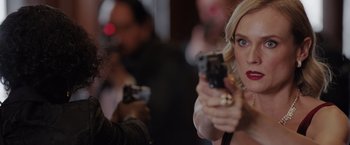 Movie still from “The 355” (2022), directed by Simon Kinberg – A woman holding a gun in front of a man; Close Up shot, Over the shoulder angle