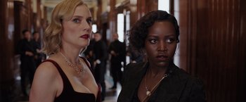 Movie still from “The 355” (2022), directed by Simon Kinberg – Two beautiful women standing next to each other in a hallway; Close Up shot, Over the shoulder angle
