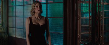 Movie still from “The 355” (2022), directed by Simon Kinberg – A woman in a black dress standing next to a window; Medium shot, Over the shoulder angle