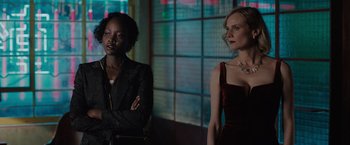 Movie still from “The 355” (2022), directed by Simon Kinberg – Two women standing next to each other in front of a window; Medium shot, Over the shoulder angle