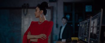 Movie still from “The 355” (2022), directed by Simon Kinberg – A woman in a red dress standing in front of a man; Medium shot, Over the shoulder angle