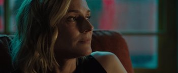 Movie still from “The 355” (2022), directed by Simon Kinberg – A person sitting on a couch; Close Up shot, Over the shoulder angle