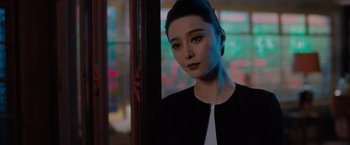 Movie still from “The 355” (2022), directed by Simon Kinberg – A beautiful young woman in a black and white dress; Close Up shot, Over the shoulder angle