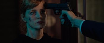 Movie still from “The 355” (2022), directed by Simon Kinberg – A woman holding a gun up to her face; Close Up shot, Over the shoulder angle