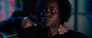 Movie still from “The 355” (2022), directed by Simon Kinberg – A woman holding a cell phone up to her face; Close Up shot, Over the shoulder angle