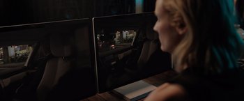 Movie still from “The 355” (2022), directed by Simon Kinberg – A woman sitting in front of a computer monitor; Medium shot, Over the shoulder angle