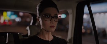 Movie still from “The 355” (2022), directed by Simon Kinberg – A woman wearing glasses sitting in the back of a car; Close Up shot, Over the shoulder angle