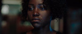 Movie still from “The 355” (2022), directed by Simon Kinberg – A person with a tear on their face; Close Up shot, Low angle