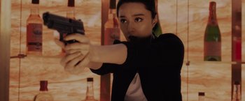 Movie still from “The 355” (2022), directed by Simon Kinberg – A woman is holding a gun in her hand; Close Up shot, Low angle