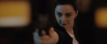 Movie still from “The 355” (2022), directed by Simon Kinberg – A woman holding a gun in her hand; Close Up shot, Over the shoulder angle