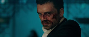 Movie still from “The 355” (2022), directed by Simon Kinberg – A person with blood on his face; Close Up shot, Over the shoulder angle