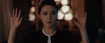 Movie still from “The 355” (2022), directed by Simon Kinberg – A person wearing a suit and tie; Close Up shot, Over the shoulder angle