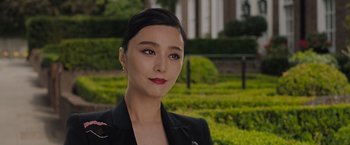 Movie still from “The 355” (2022), directed by Simon Kinberg – A woman in a black jacket standing next to a hedge; Close Up shot, Low angle