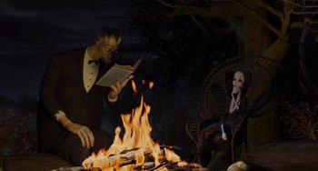 Movie still from “The Addams Family 2” (2021), directed by Greg Tiernan – An illustration of a man reading a book next to a fire; Medium shot, Over the shoulder angle