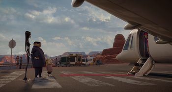 Movie still from “The Addams Family 2” (2021), directed by Greg Tiernan – An airplane parked on a runway with a person and a small child standing on the ground; Wide shot, High angle