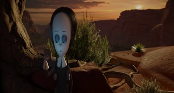 Movie still from “The Addams Family 2” (2021), directed by Greg Tiernan – An animated character holding a cell phone in a desert landscape; Medium shot, High angle