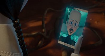 Movie still from “The Addams Family 2” (2021), directed by Greg Tiernan – A person holding up a cell phone with an image on it; Extreme Close Up shot, Over the shoulder angle