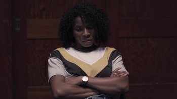 Movie still from “The Amityville Moon” (2021), directed by Thomas J. Churchill – A woman with her arms crossed wearing a watch; Close Up shot, Low angle